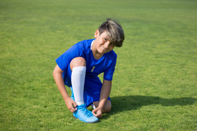 Generica - Bambino con maglia azzurra che gioca a calcio